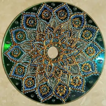 Upcycled CD hand-painted using a soft colour palette into an intricate floral mandala.