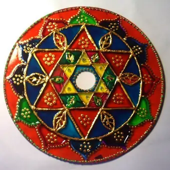 Upcycled CD hand-painted with a variety of vivid colours, outlined with a golden acrylic into a striking mandala design.