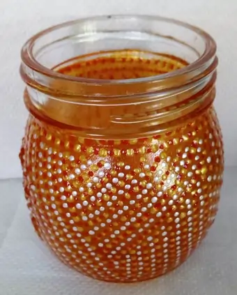 Upcycled glass jar, hand-painted with an amber glass paint and textured with red, orange and white dotted pattern.