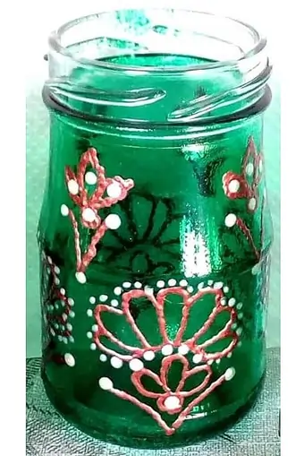 Upcycled glass tumbler, hand-painted with green glass paint and textured with orange and white floral ornamental designs.